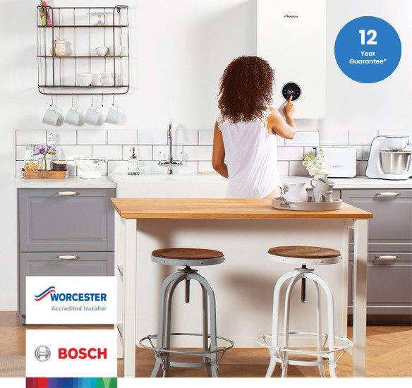 Homeowner adjusting a Worcester Bosch boiler in a modern kitchen with 12 year guarantee badge